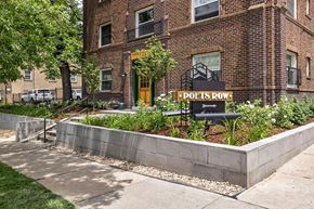 Denver apartment for rent - A brick building with a green door and a sign that says "Poets Row.".