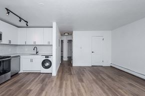 Denver apartment for rent - A kitchen with white cabinets and a wooden floor.
