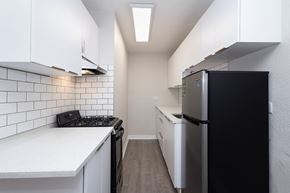 Denver apartment for rent - A kitchen with black appliances and white cabinets.