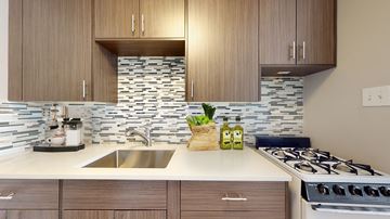 Denver apartment for rent - A modern kitchen with wooden cabinets and a stone backsplash.