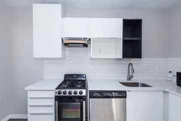 Denver apartment for rent - A modern kitchen with a stainless steel dishwasher and white cabinetry.