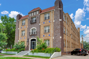 Denver apartment for rent - A large brick building with a black car parked in front.