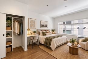 Denver apartment for rent - A bedroom with a bed, chair, and window.
