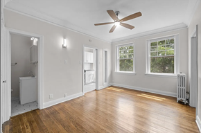 Denver apartment for rent - an empty living room with a ceiling fan and wood floors