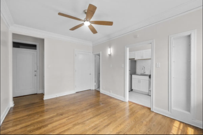 Denver apartment for rent - an empty living room with a ceiling fan and a kitchen
