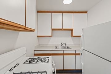 Denver apartment for rent - A white kitchen with a stove and sink.