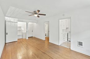 Denver apartment for rent - A room with a ceiling fan and wooden floors.