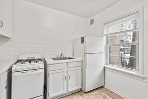 Denver apartment for rent - A white kitchen with a stove, sink, and refrigerator.