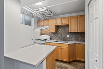Denver apartment for rent - A kitchen with wooden cabinets and a white countertop.