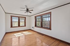 Denver apartment for rent - A room with wooden floors and two windows.