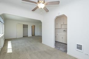 Denver apartment for rent - A spacious room with a ceiling fan and a cabinet.