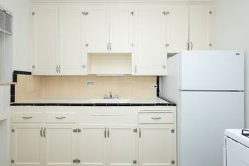 Denver apartment for rent - A white kitchen with a refrigerator on the right.