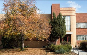 Denver apartment for rent - A tree with orange leaves is in front of a red brick building.