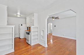 Denver apartment for rent - A white kitchen with wooden floors and a ceiling fan.