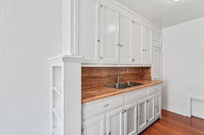 Denver apartment for rent - A kitchen with white cabinets and a wooden countertop.