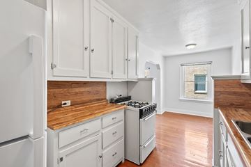 Denver apartment for rent - A kitchen with white cabinets and a wooden countertop.