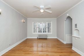 Denver apartment for rent - A room with a ceiling fan and a window with a view of a city.