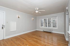 Denver apartment for rent - A room with a ceiling fan and a window with a view of a city.