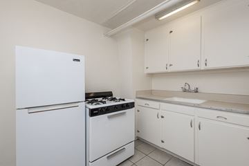 Denver apartment for rent - A white fridge and stove in a kitchen with white cabinets.