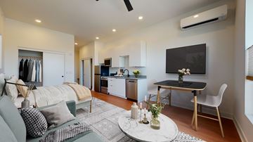 Denver apartment for rent - A modern living room with a grey sofa and a black and white rug.