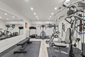 Denver apartment for rent - A gym with a variety of equipment including a treadmill, weights, and a bench.