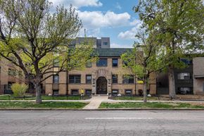 Denver apartment for rent - A building with a green roof and a tree in front of it.