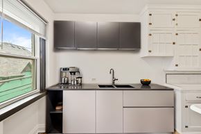 Denver apartment for rent - A kitchen with a black countertop and white cabinets.