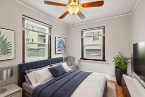 Denver apartment for rent - A bedroom with a bed, a ceiling fan, and a window with blinds.