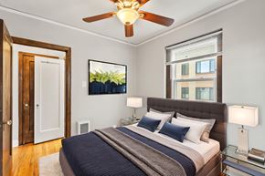 Denver apartment for rent - A bedroom with a bed, a ceiling fan, and a window.