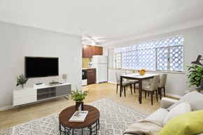 Denver apartment for rent - A living room with a television, a coffee table, and a dining table.