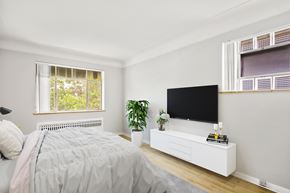 Denver apartment for rent - A bedroom with a bed, a television, and a window.