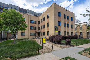 Denver apartment for rent - A building with a yellow sign in front of it.
