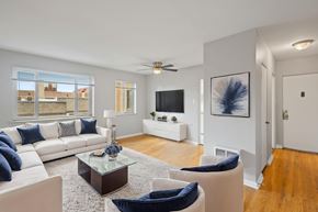 Denver apartment for rent - A living room with a white couch, blue pillows, and a glass coffee table.