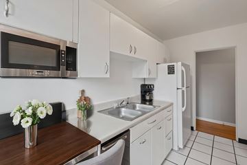 Denver apartment for rent - A kitchen with white cabinets and a black counter top.