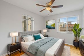 Denver apartment for rent - A bedroom with a bed, nightstand, and a ceiling fan.