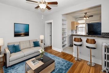 Denver apartment for rent - A living room with a white couch, a coffee table, and a painting on the wall.