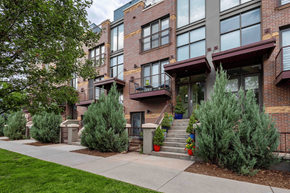 Denver townhouse for rent - the front of a brick apartment building with stairs and trees in front