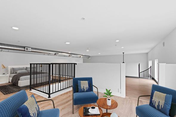 Denver apartment for rent - a living room with blue chairs and a bed in a room with a staircase