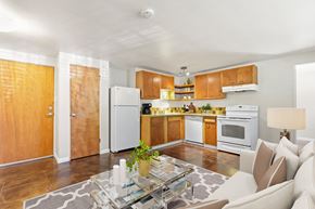Denver apartment for rent - a kitchen and living room with white appliances and wooden cabinets