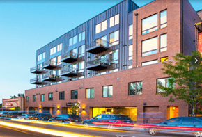 Denver apartment for rent - a large brick building with cars parked in front of it