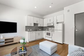 Denver apartment for rent - a kitchen and living room with white cabinets and a white coffee table