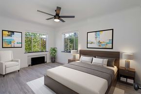 Denver apartment for rent - A bedroom with a large bed, a fireplace, and a ceiling fan.