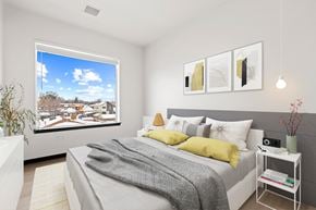 Denver apartment for rent - a bedroom with a bed and a large window