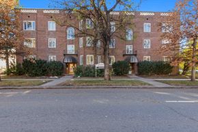 Denver apartment for rent - A red brick building with a tree in front of it.