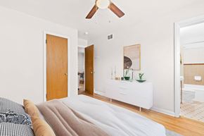 Denver apartment for rent - A bedroom with a bed and a ceiling fan.
