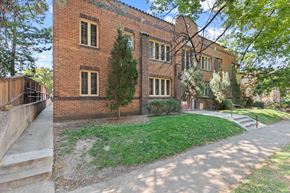 Denver apartment for rent - the exterior of a brick building with a sidewalk and grass