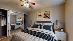 Denver apartment for rent - A bedroom with a large bed and a ceiling fan.