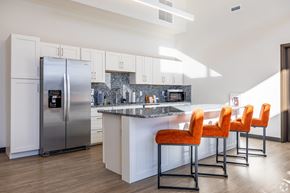 Elkhorn apartment for rent - A kitchen with a refrigerator, bar stools, and a marble countertop.