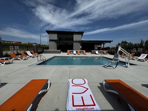 Elkhorn apartment for rent - A pool area with loungers and a sign that reads "LivingEVO.com".