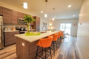 Elkhorn apartment for rent - a kitchen with a long island with orange chairs